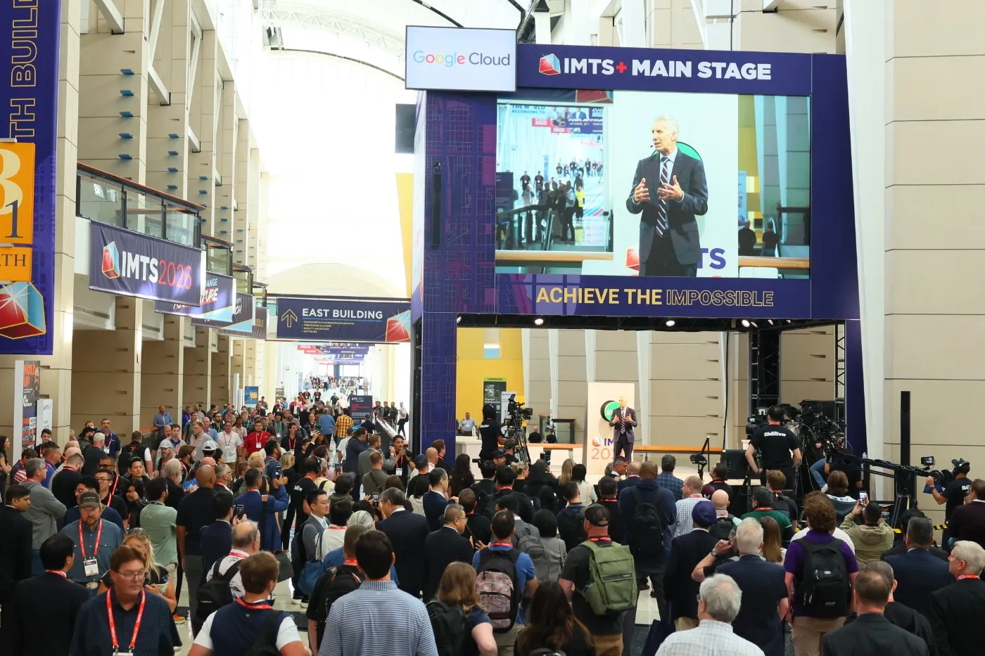 The IMTS 2026 show floor at McCormick Place — a crowd gathered around the IMTS+ Main Stage in the East Building concourse